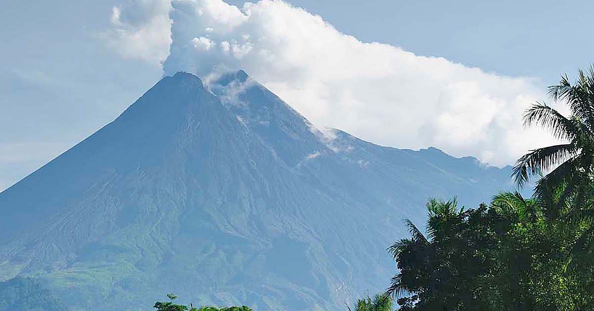 Volcano with smoke billowing out from the top.