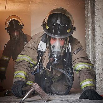 Firemen on site wearing safety helmet, mask and respiratory equipment